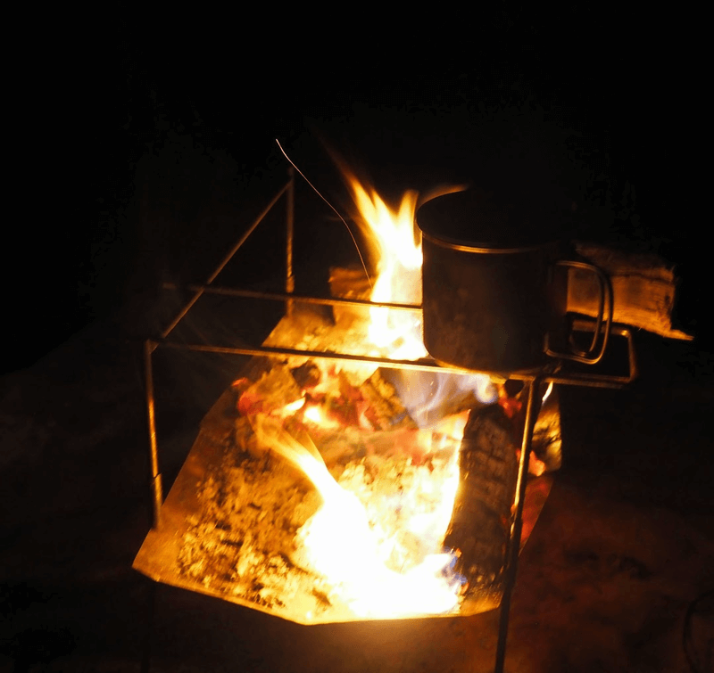 TokyoCamp焚火台でマグカップを温めている写真。デフォルトのパーツだと、火からの距離がけっこう遠い