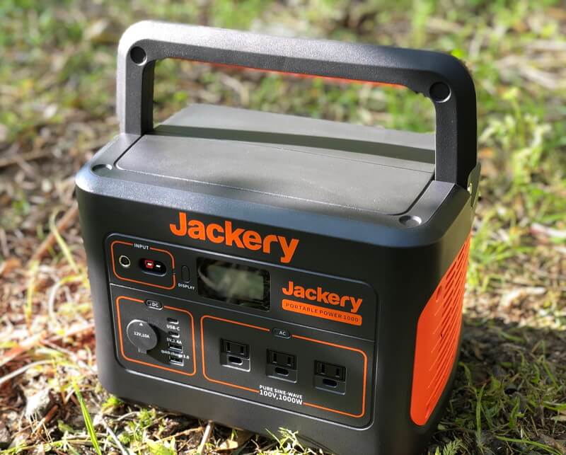 Jackeryポータブル電源1000をキャンプ場の地面に置いておいている写真。右上から引き。
