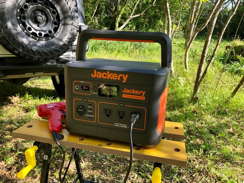 Jackeryポータブル電源1000を実際にキャンプ場で使う、電動ドライバーを接続し、背景に車が写っている