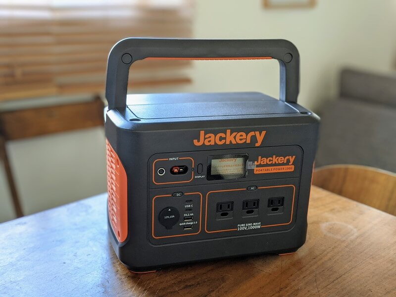 Jackeryポータブル電源1000を家庭のテーブルの上に置いている様子。ハンドルを上げた状態、左上からの視点