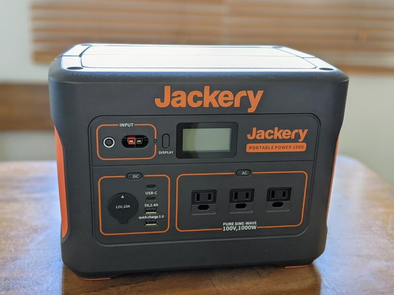 Jackeryポータブル電源1000を家庭のテーブルの上に置いている様子。ハンドルを下げ、正面からの写真